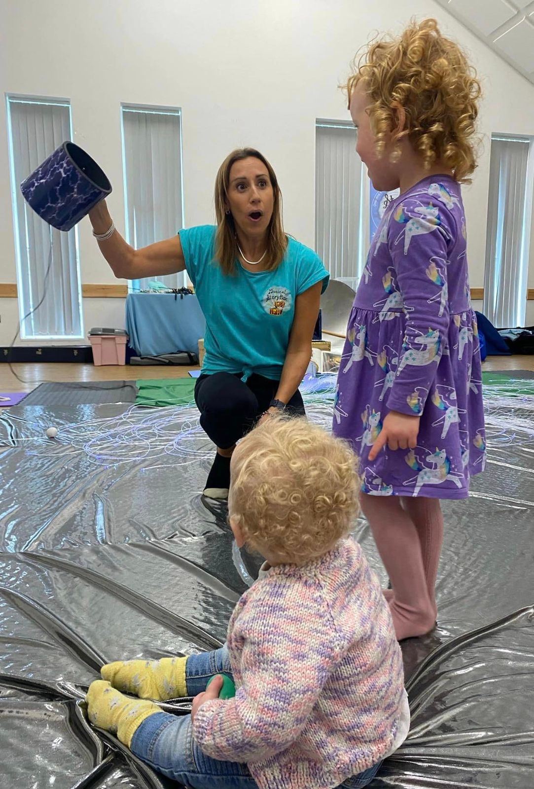 A StoryBox leader playing with toddlers in class